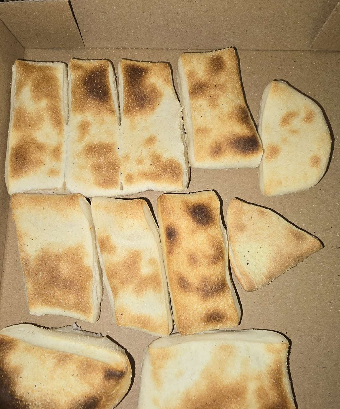 Goldbraun gebackene Pizzabrötchen im Karton